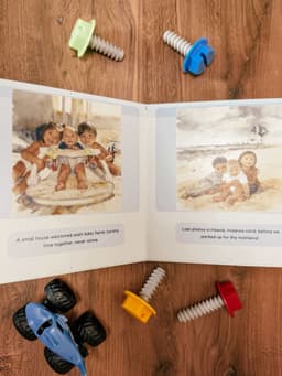 Personalized board book open on a table showing watercolor illustrations with toys around it