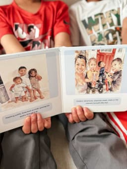 Child holding personalized board book open showing watercolor illustrations and story